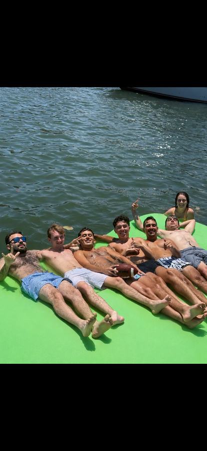 Guys on green floating mat Fort Lauderdale pontoon sandbar